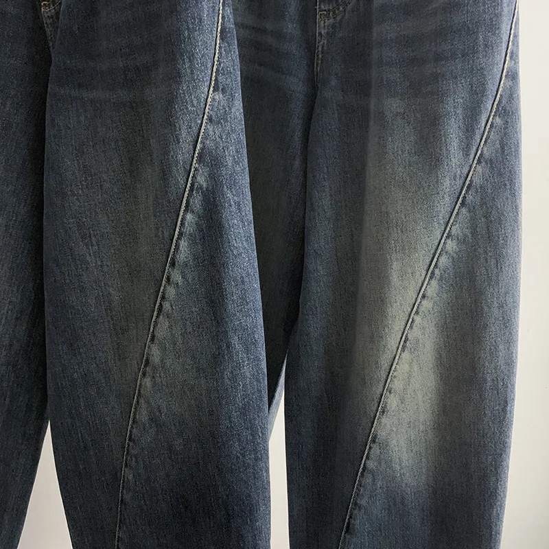 Modne jeansy o luźnym kroju z prostymi nogawkami i szerokimi nogawkami, z efektem spranej tkaniny i skręcanymi szwami.