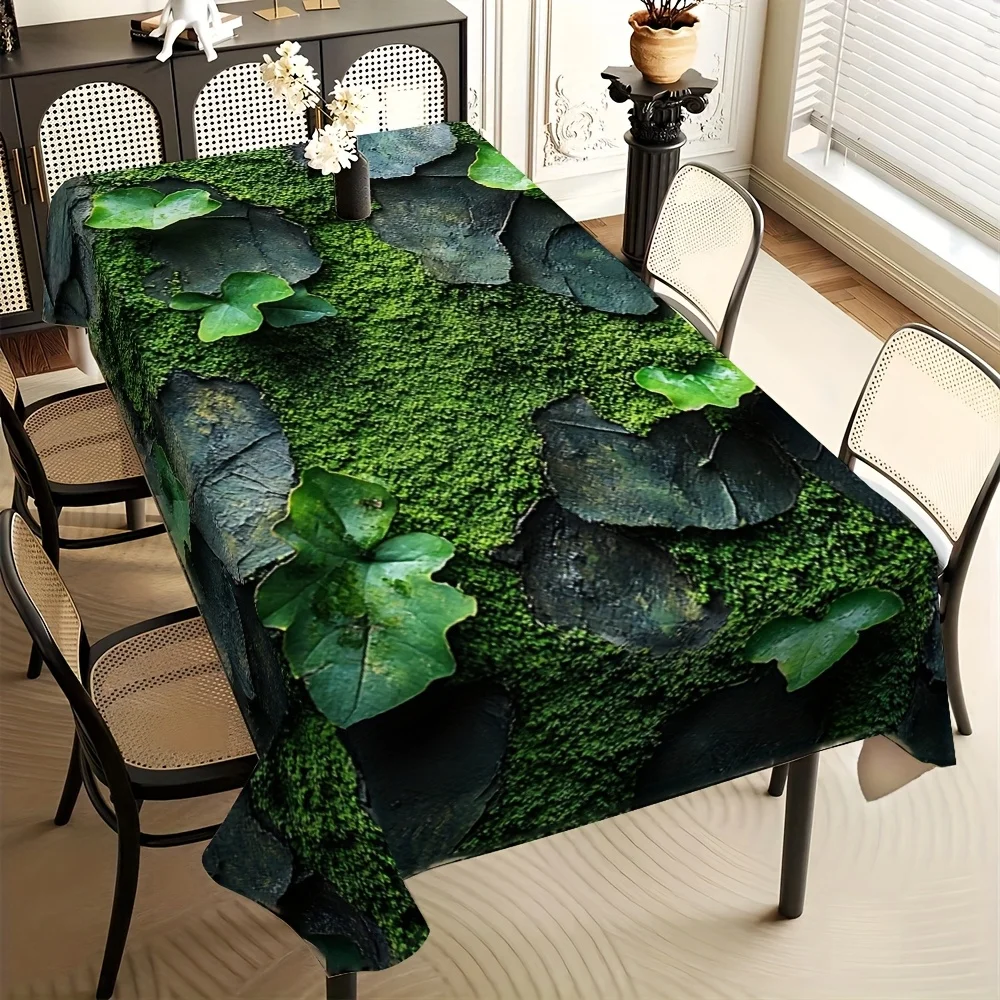 Green plant-printed tablecloth, realistically depicting moss covering stones.
