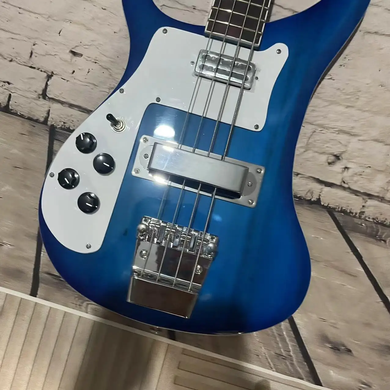 In stock, there is a left hand four chord Rickenbaker electric bass with a gradient blue body and chrome plated accessories. The