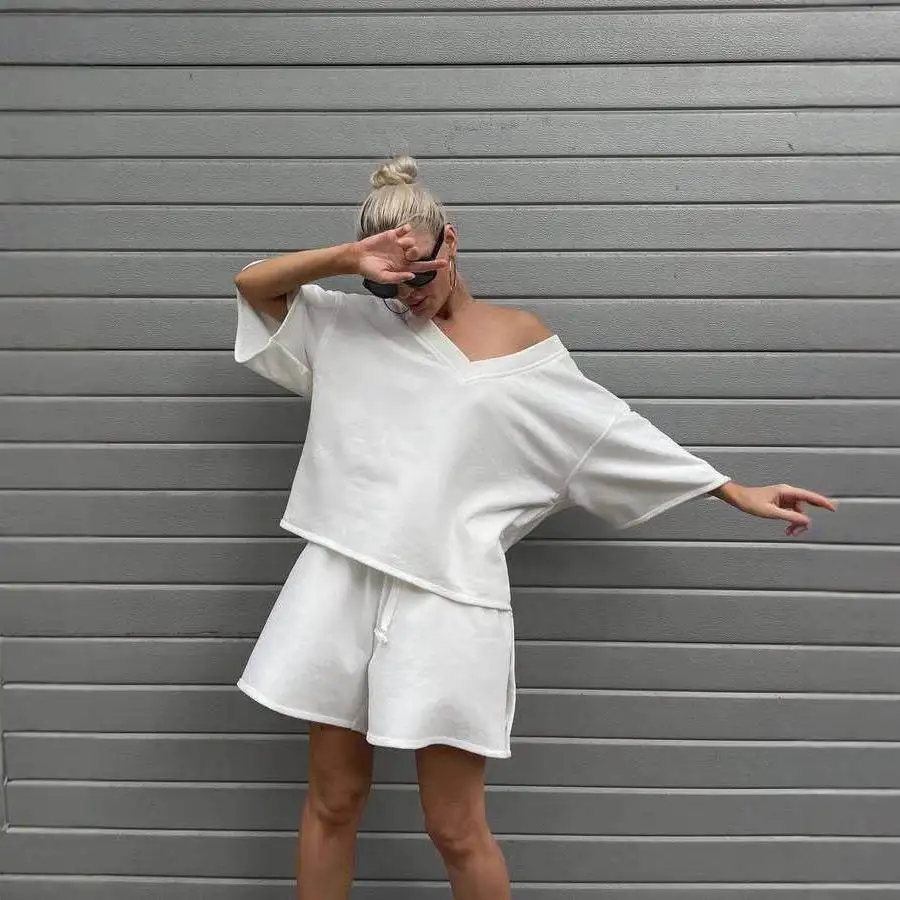 

Повседневный однотонный комплект: топ с V-образным вырезом и короткими рукавами на пуговицах и шорты. Модный женский комплект из двух предметов в уличном стиле: брюки-бомберы со средней/заниженной талией.