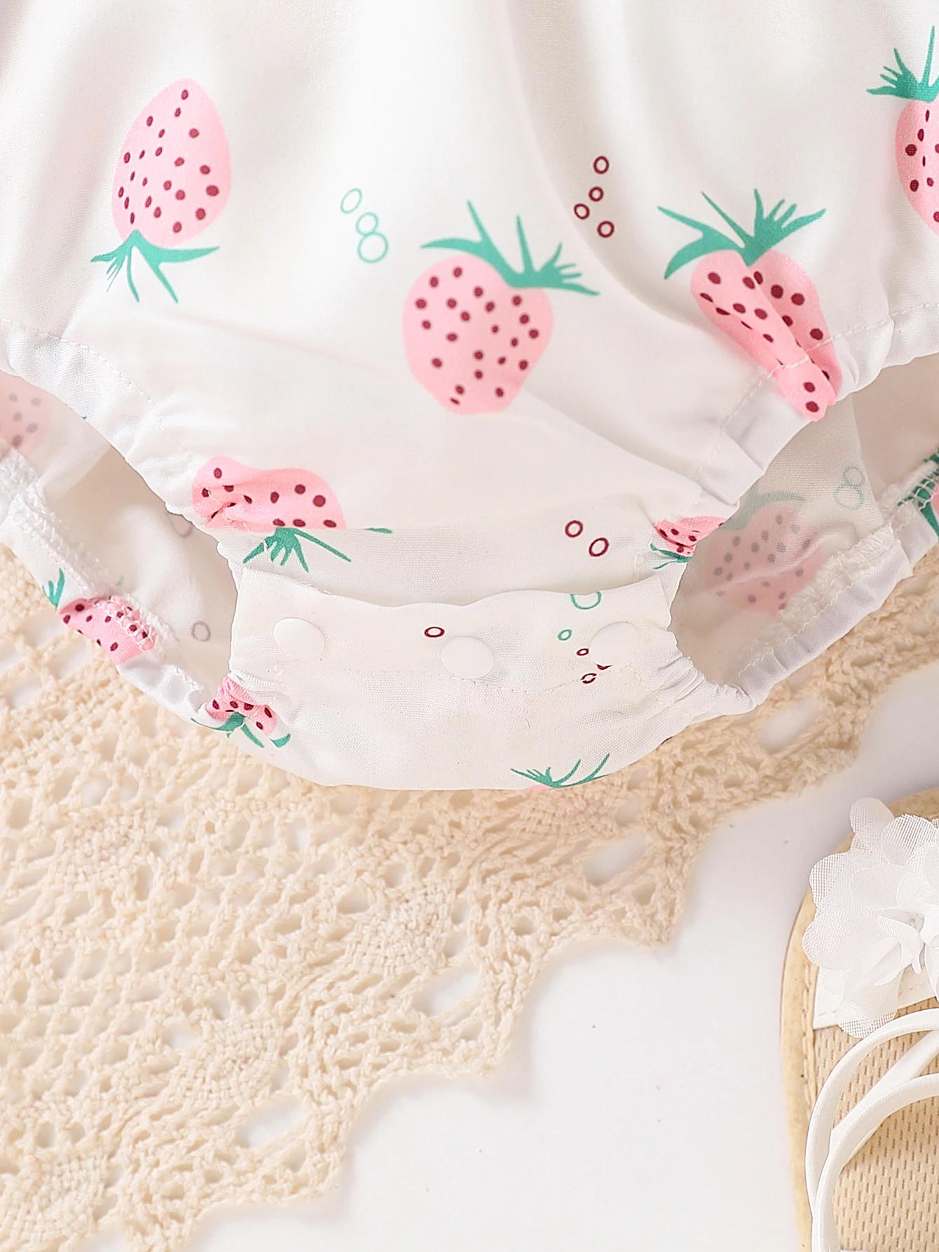 فتاة لطيفة في رومبير كاجوال بنمط الفراولة بالكامل، بما في ذلك ملحق القبعة، للصيف.