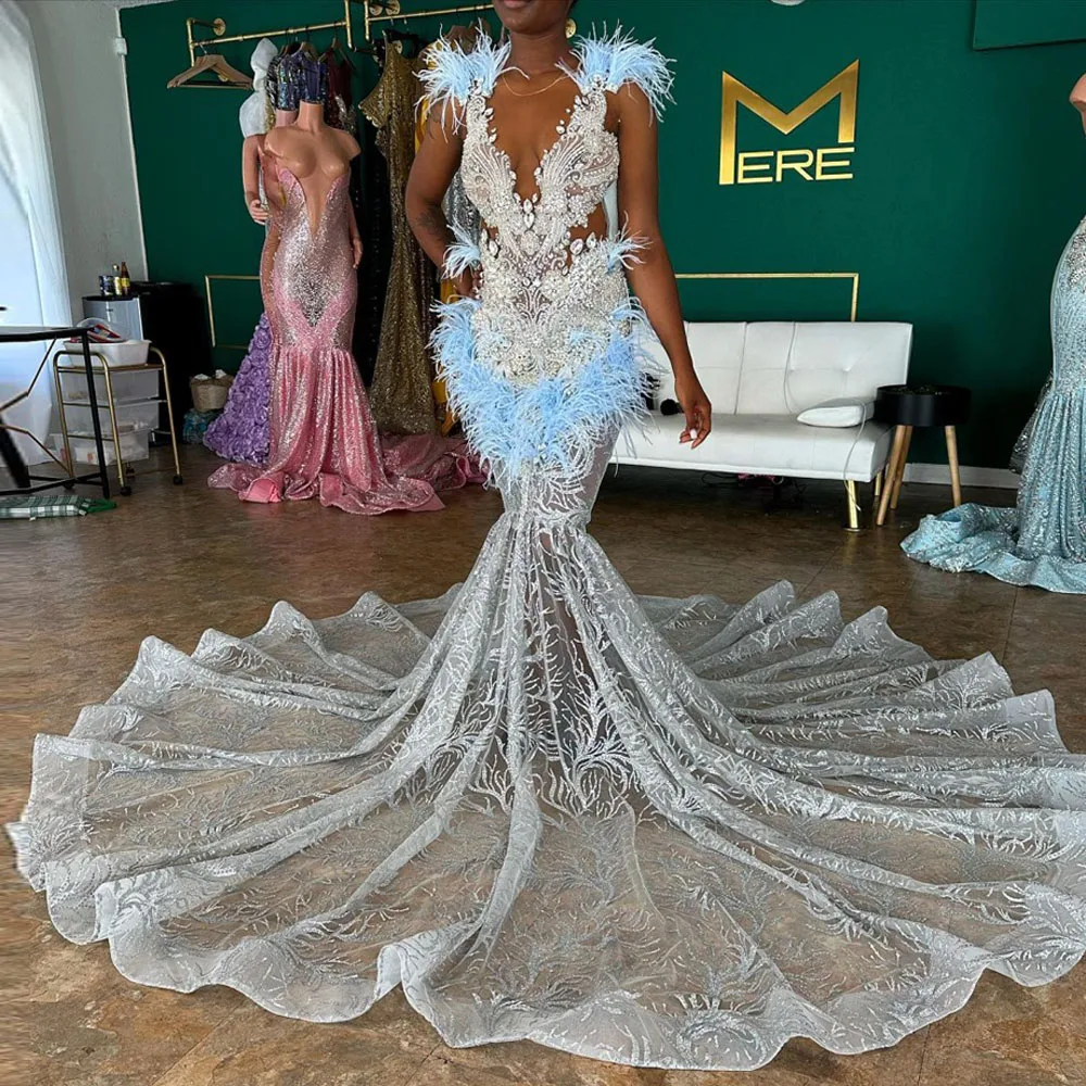 

Elegant White Lace Dress With Blue Feather Accents Features Deep V Neckline And Long Train Detailed Embroidery And Sheer Fabric