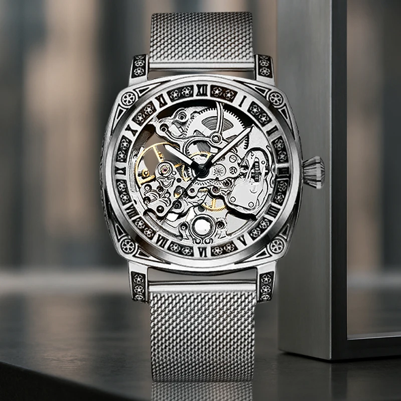 ساعة ميكانيكية أوتوماتيكية بالكامل بحزام شبكي فضي وأنيق على طراز المؤشر وأرقام رومانية للرجال.