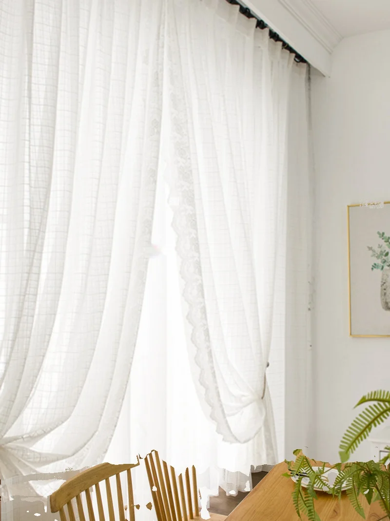 White lace curtains hanging in a bright living room