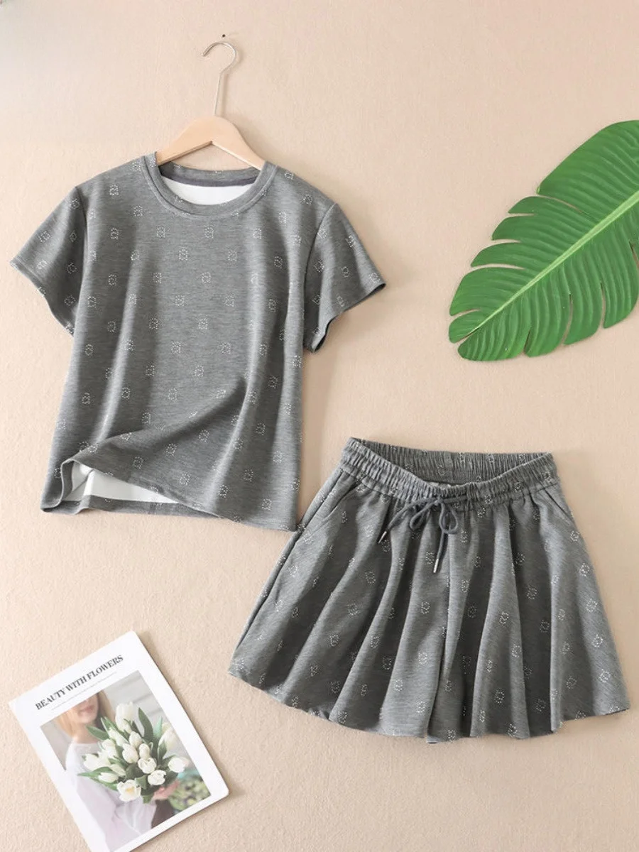 

Модный дизайнерский комплект из двух предметов: футболка с коротким рукавом и юбка с завязками, летний наряд с бриллиантовым декором.