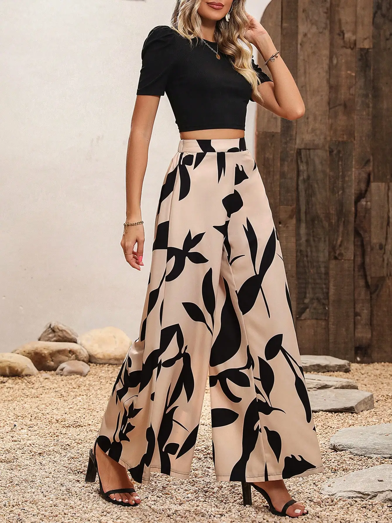 

Черный вязаный укороченный топ и бежевые широкие брюки с цветочным принтом, комплект на весну-лето