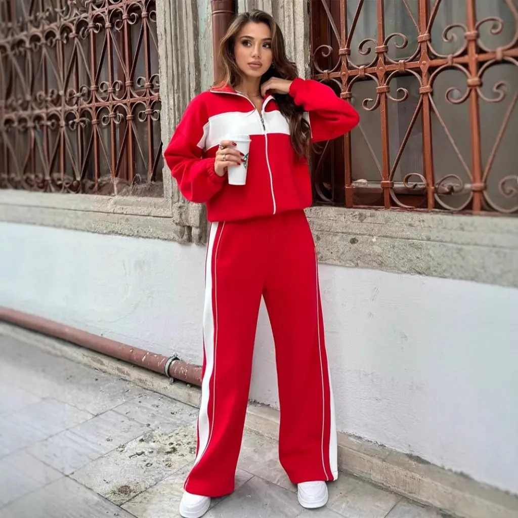 Damski zestaw w stylu casual streetwear: bluzka z wysokim kołnierzem i zamkiem błyskawicznym oraz proste spodnie w kontrastowe paski, dwuczęściowy komplet.