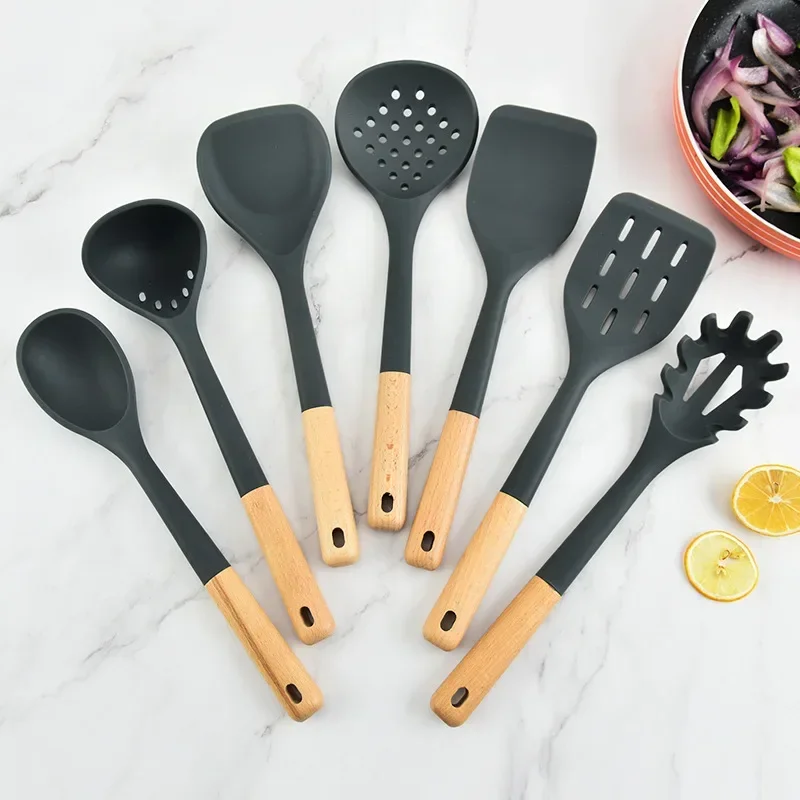

Silicone kitchenware set with wooden handles. Kitchen tools: silicone spatula, strainer, frying spatula