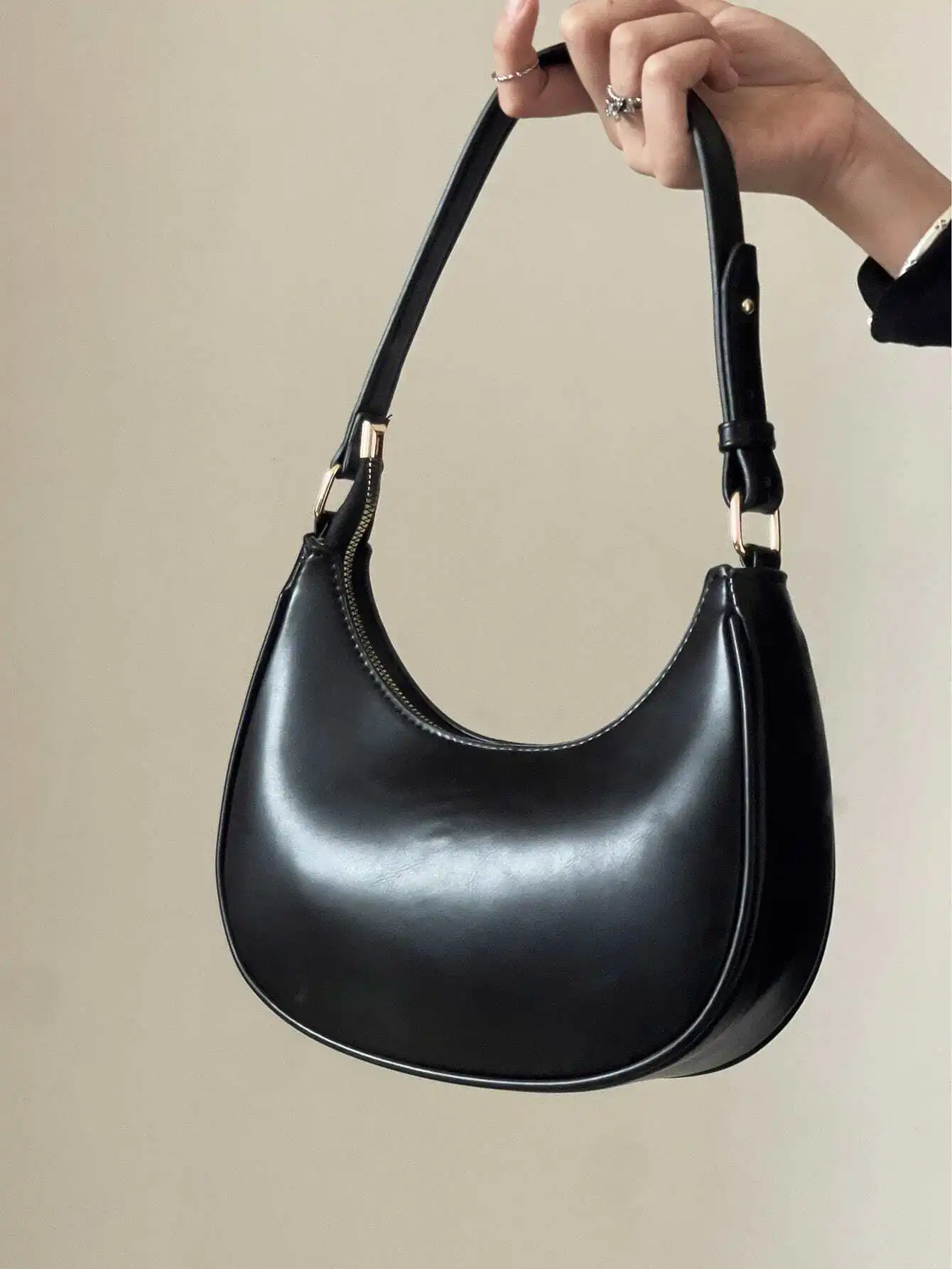 

Black Crescent-Shaped Shoulder Bag with Smooth Finish and Gold Hardware