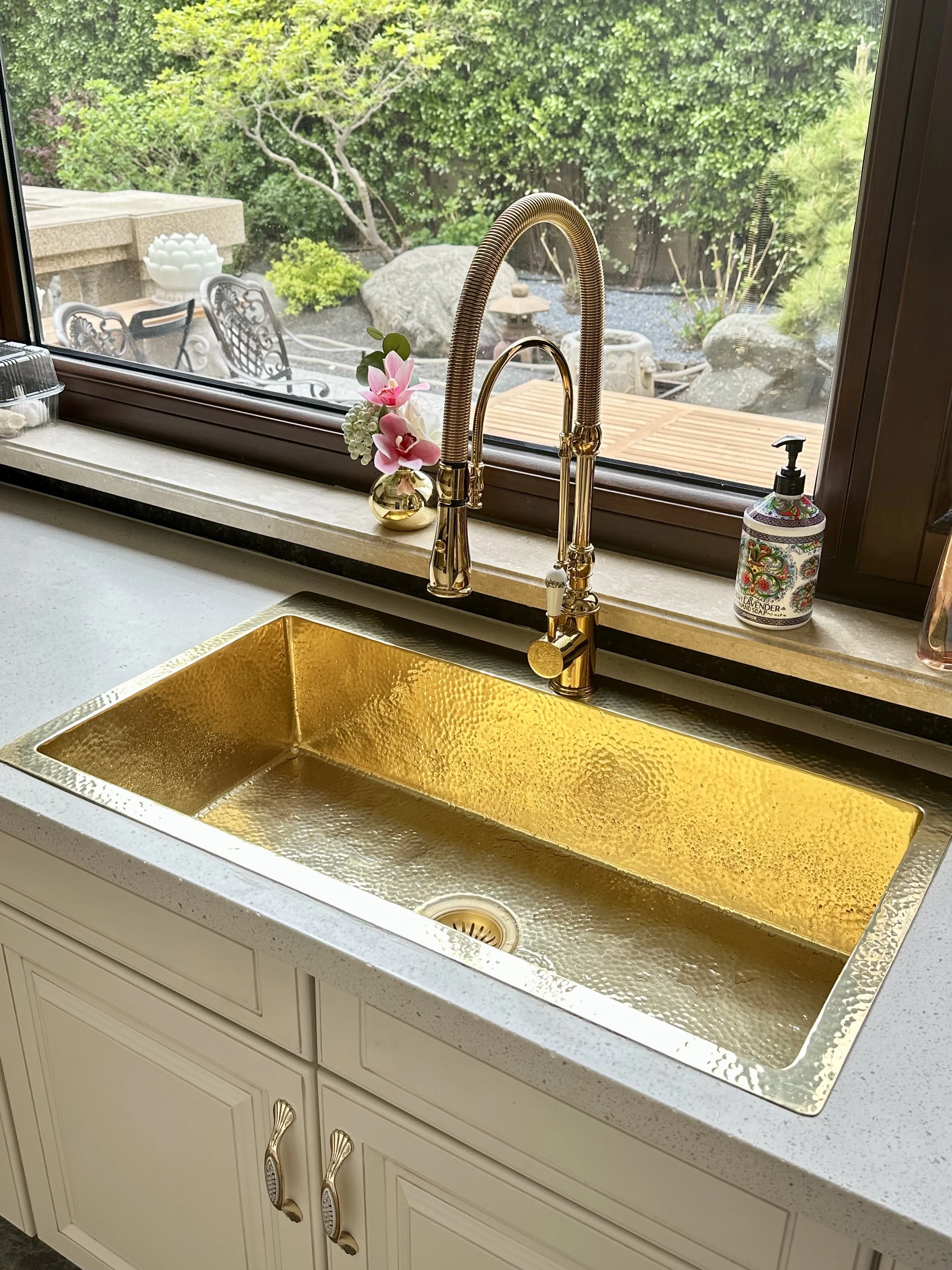 French retro kitchen with large single sink embedded in island countertop, water bar, sink, pure copper and gold basin