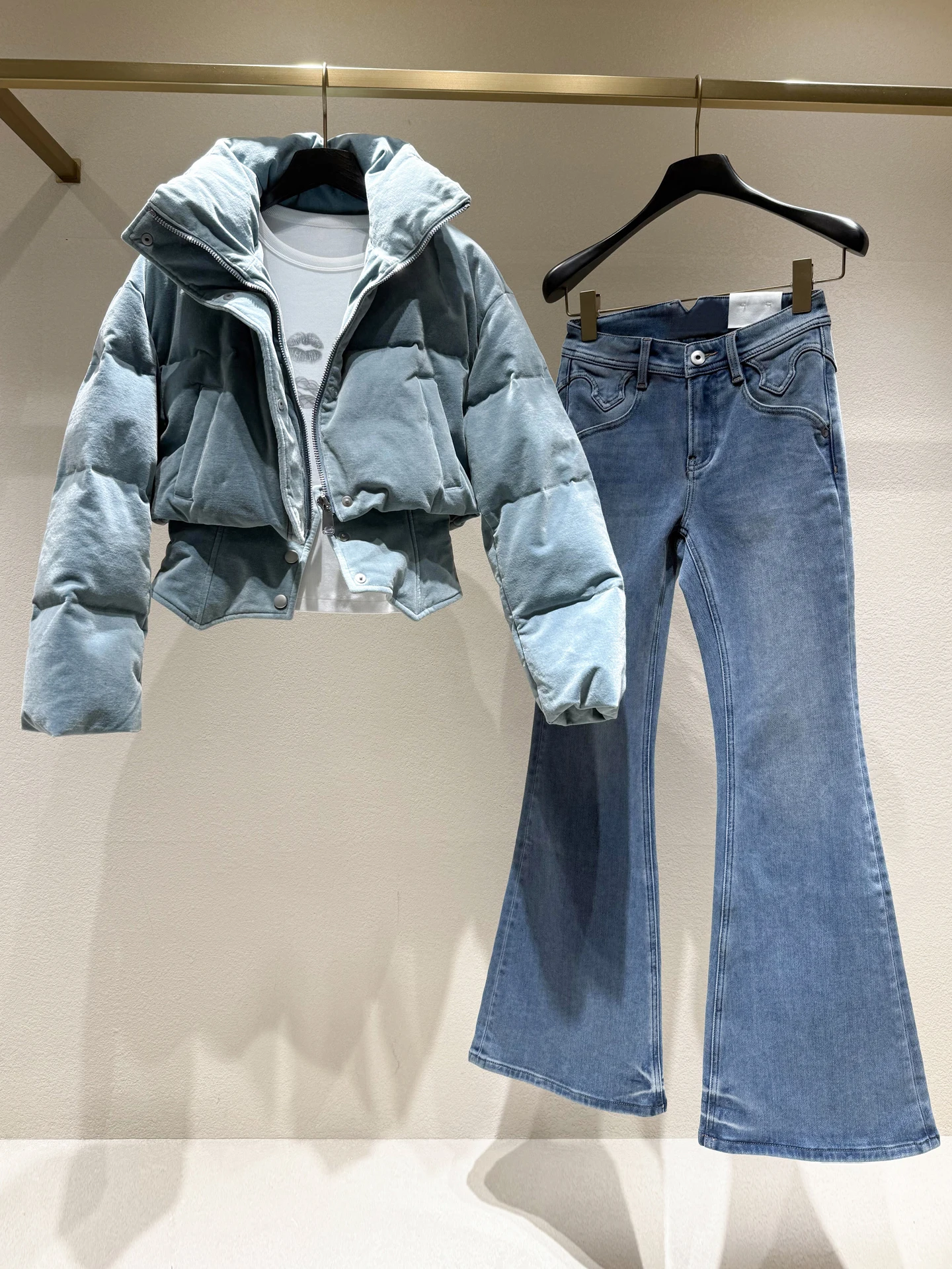 ชุดแฟชั่นฤดูหนาวสำหรับผู้หญิงระดับไฮเอนด์ เสื้อแจ็คเก็ตขนเป็ดเทียมและกางเกงยีนส์ทรงบาน ให้ความอบอุ่น เหมาะสำหรับการเดินทาง ผลิตจากเส้นใยโพลีเอสเตอร์ ปิดด้วยซิป