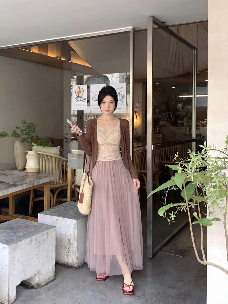 

Ретро-комплект из трех предметов: кружевной топ-халтер, кардиган и сетчатая юбка. Модный повседневный женский ансамбль с длинным рукавом и V-образным вырезом. Весна 2026.