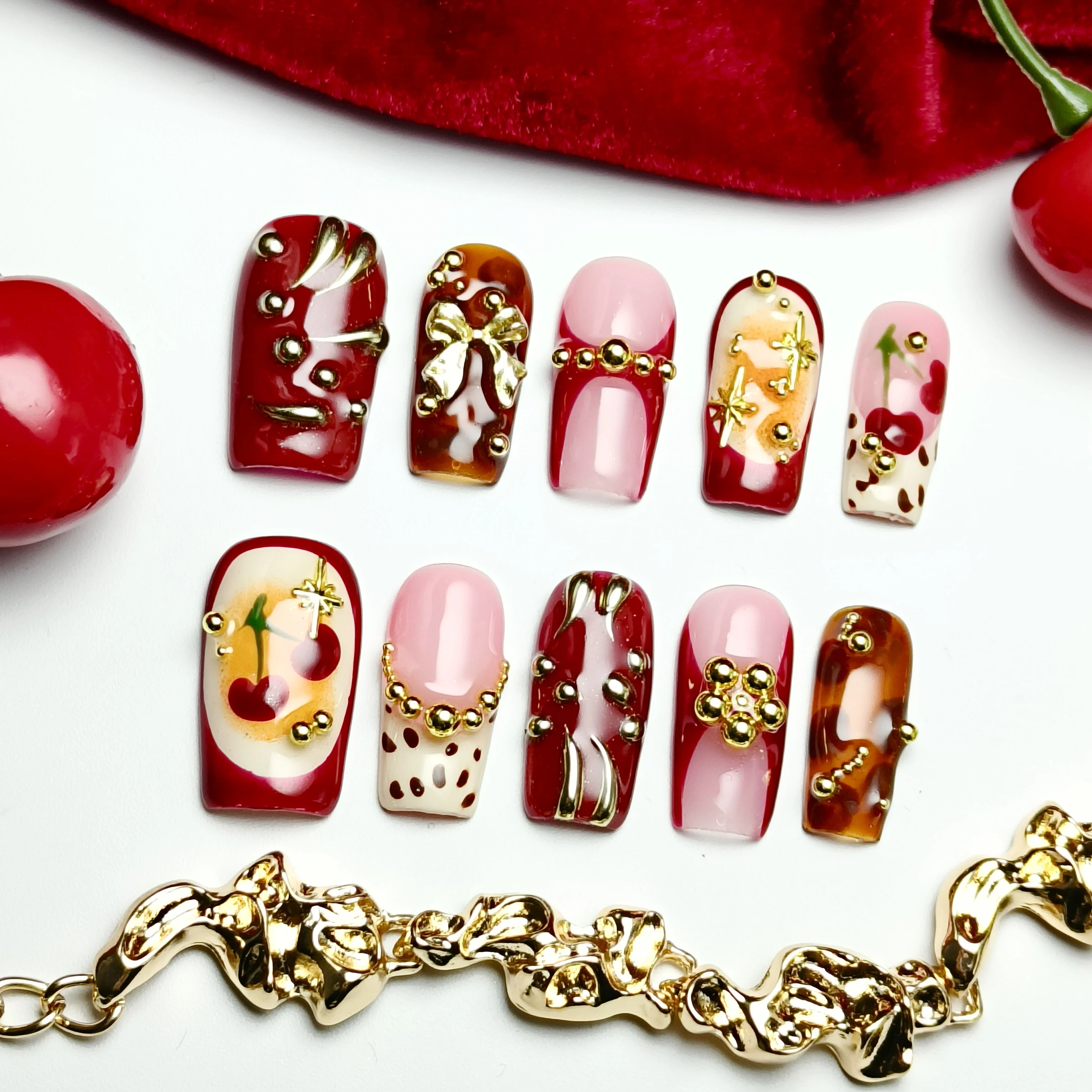 

Hand-made rectangular artificial nail with a red-gold cherry blossom pattern, and gold beads as decorations – suitable for women