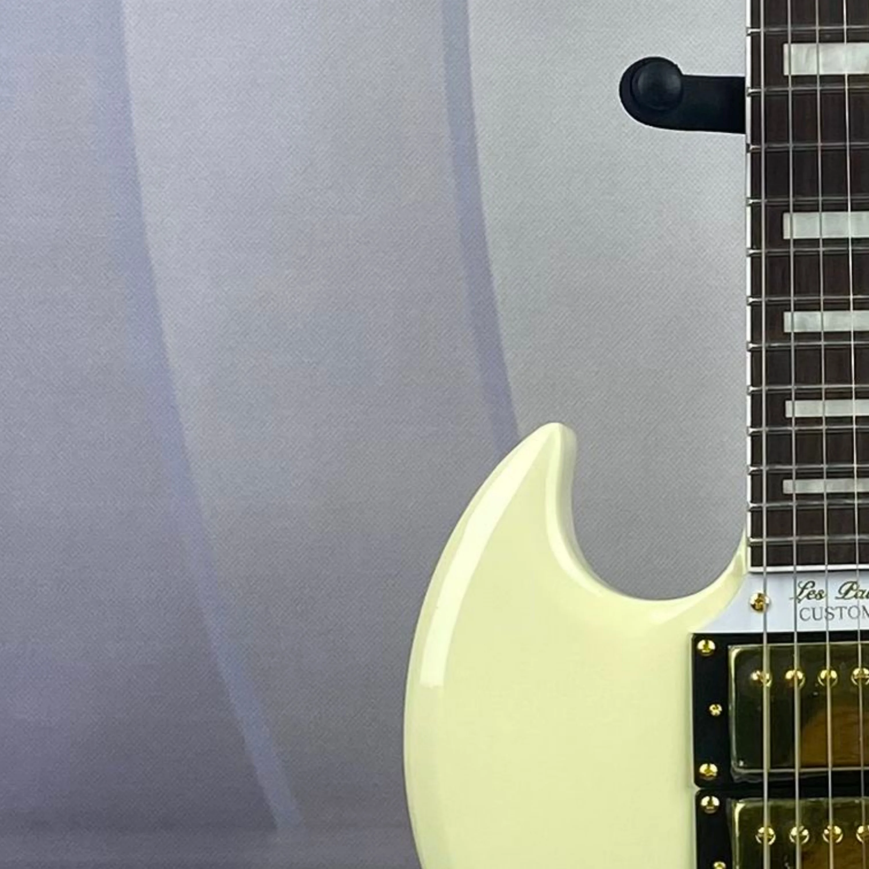 

Кремово-белая электрогитара с золотой фурнитурой, грифом из палисандра и корпусом из красного дерева.