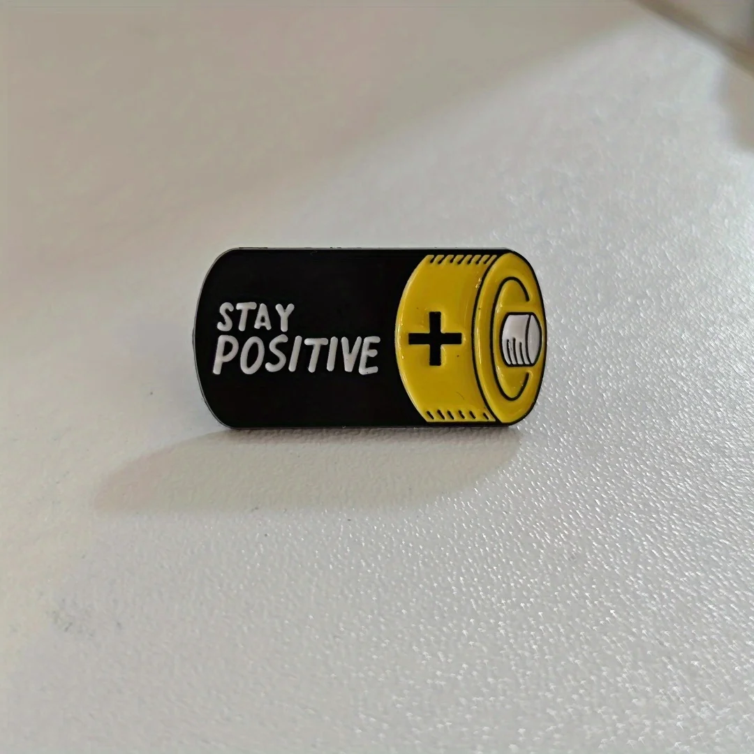 A unique and niche brooch in a battery style, promoting optimism for daily wear by men and women.