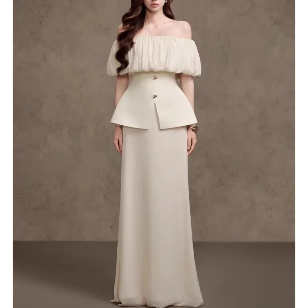 

Dreamy off-white off-shoulder gown with ruffle top and flowing skirt, a stunning choice for special occasions.