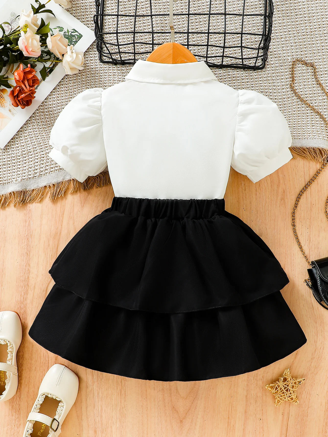 The new summer girls\' bubble-sleeved blouses are paired with bow accessories and a black half-length cake skirt