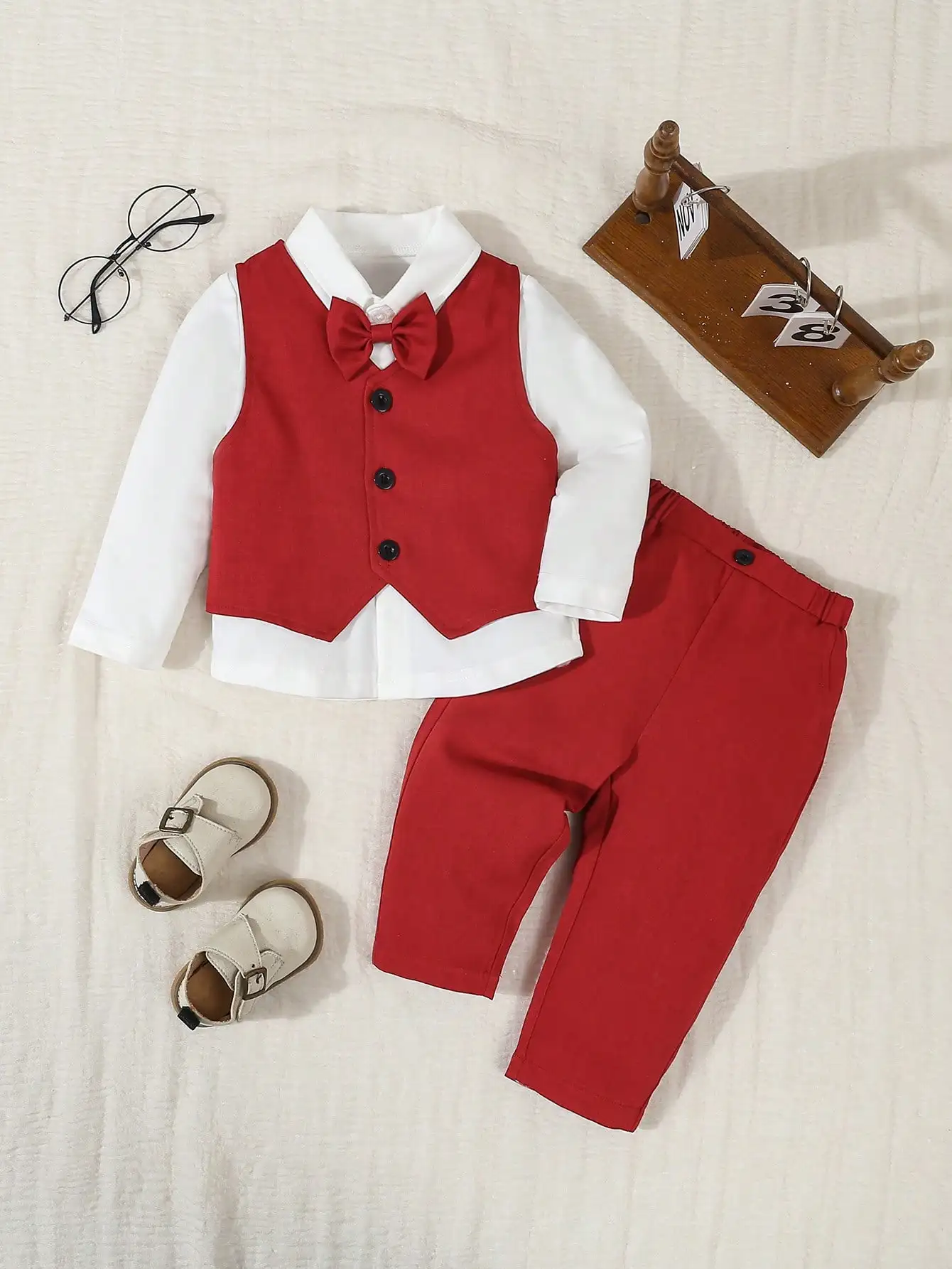 

Комплект из 3 предметов для мальчика: белая рубашка с длинным рукавом, красный жилет с галстуком-бабочкой, брюки на резинке.