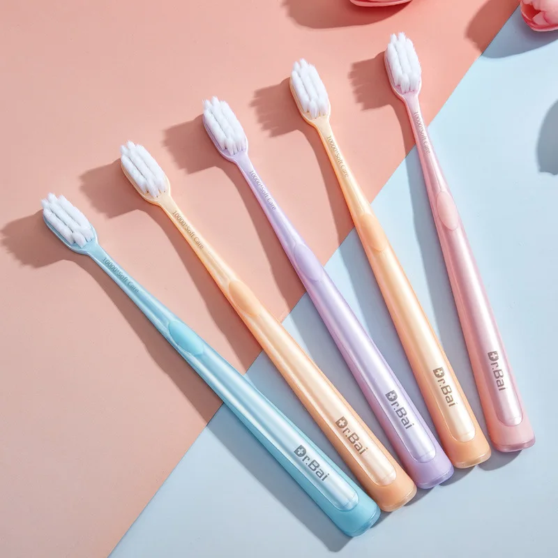 Adult soft bristle toothbrush for home use in a five-piece family combination pack