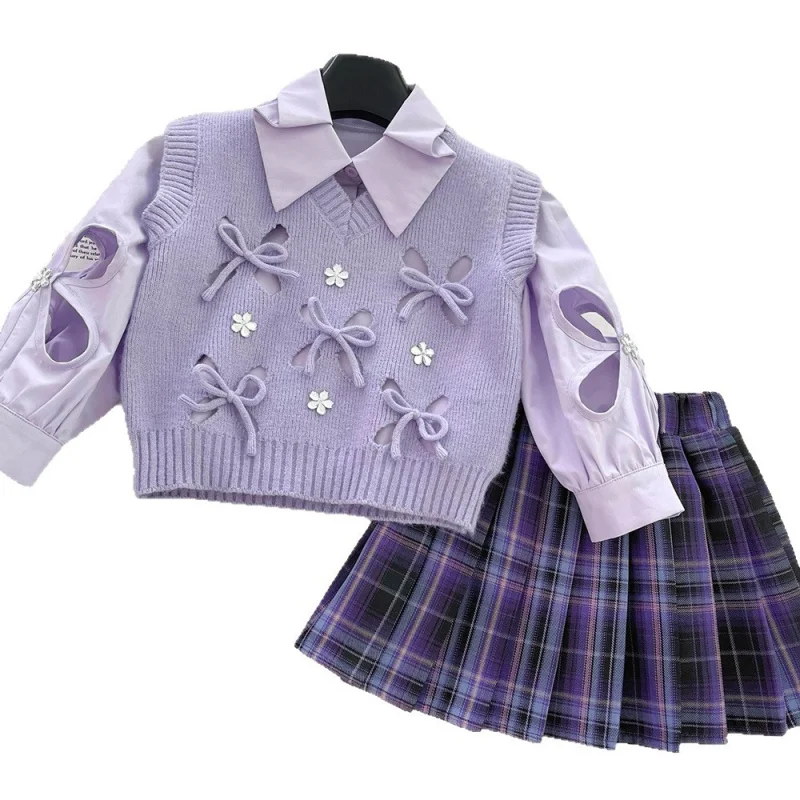 

Новый модный комплект из трех предметов: светло-фиолетовый универсальный вязаный жилет с бантом, рубашка и клетчатая юбка для девочек, весна-осень 2026