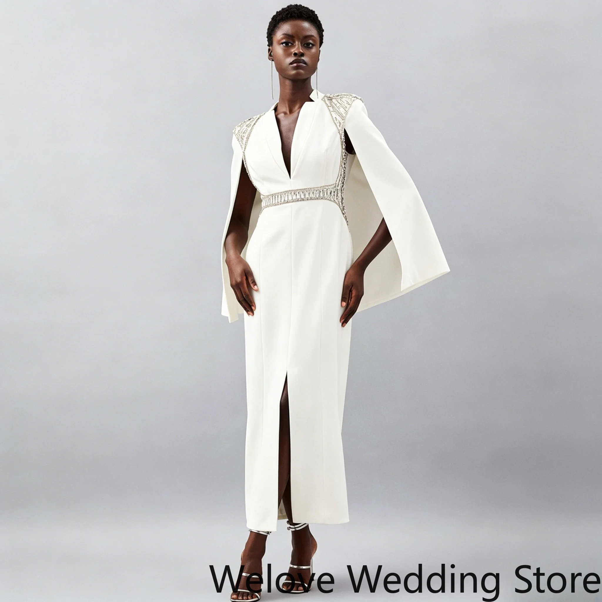 White Formal Midi Dress featuring a dramatic cape sleeve design, a deep V-neckline and a sparkling crystal-embellished waistband
