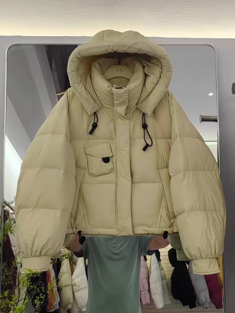 เสื้อแจ็คเก็ตขนเป็ดสำหรับผู้หญิง รุ่นใหม่ ปี 2025 ฤดูหนาว แบบสั้นมีฮู้ด สไตล์เกาหลี หนา ทรงขนมปัง อเนกประสงค์ ขนเป็ดขาว  เสื้อโค้ทแฟชั่น