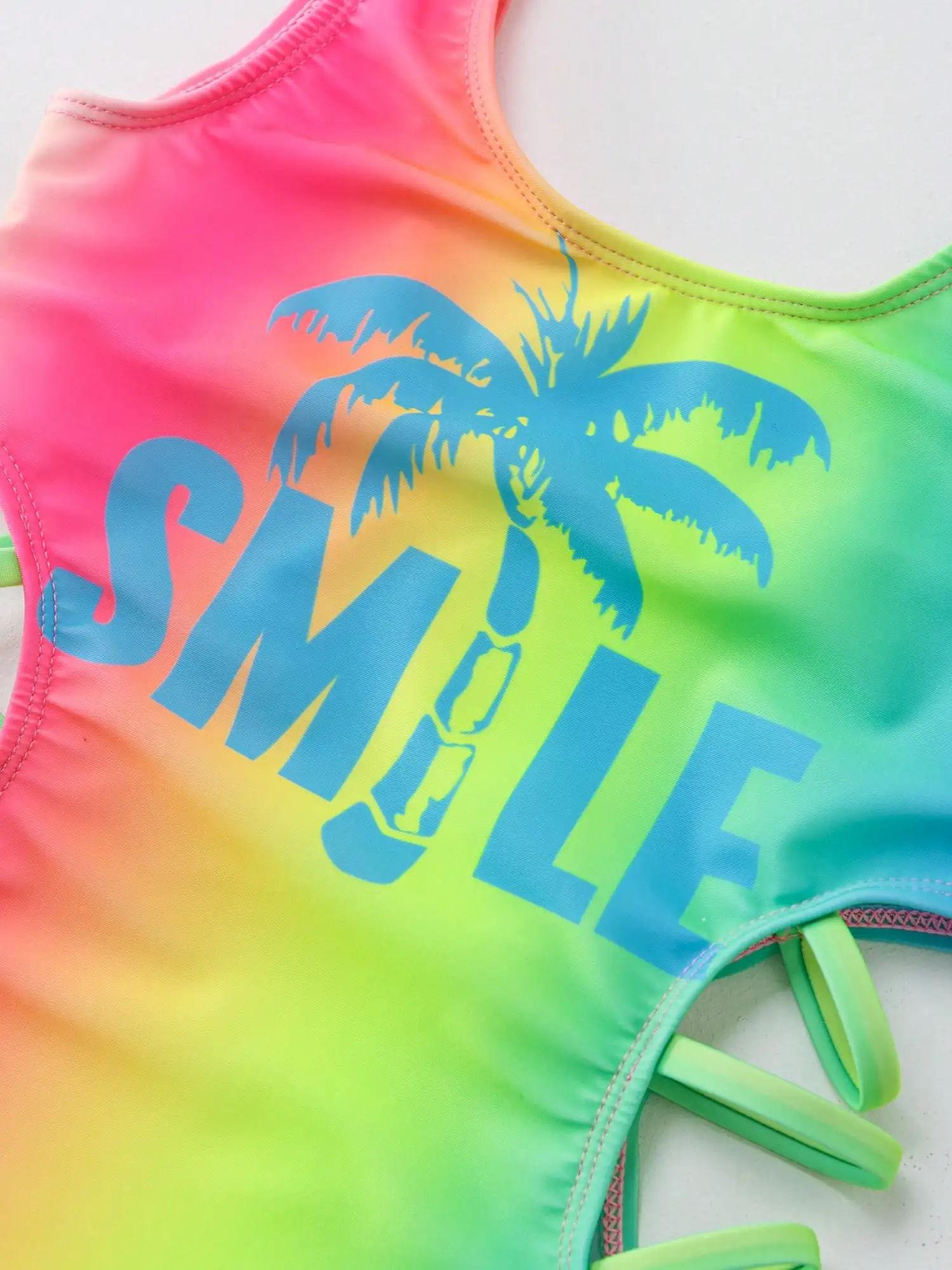 

Цельный купальник с вырезами по бокам и градиентным радужным принтом