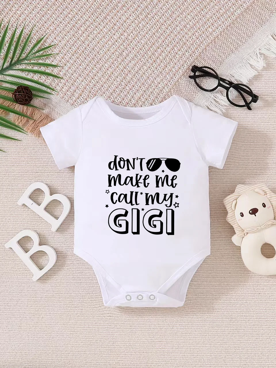 Playful letter-printed baby short-sleeve triangle bodysuit. Button closure for easy dressing