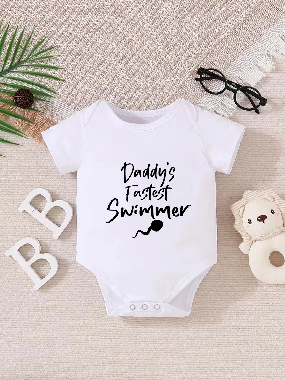 Playful letter-printed baby short-sleeve triangle bodysuit. Button closure for easy dressing