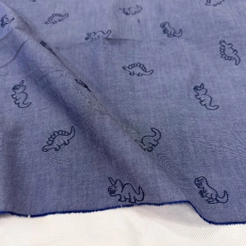 

Denim Fabric 100% Cotton Blue Cartoon Dinosaur Embroidery Comfortable Breathable Summer Boys Shirt Short Bag Fabric for Sewing