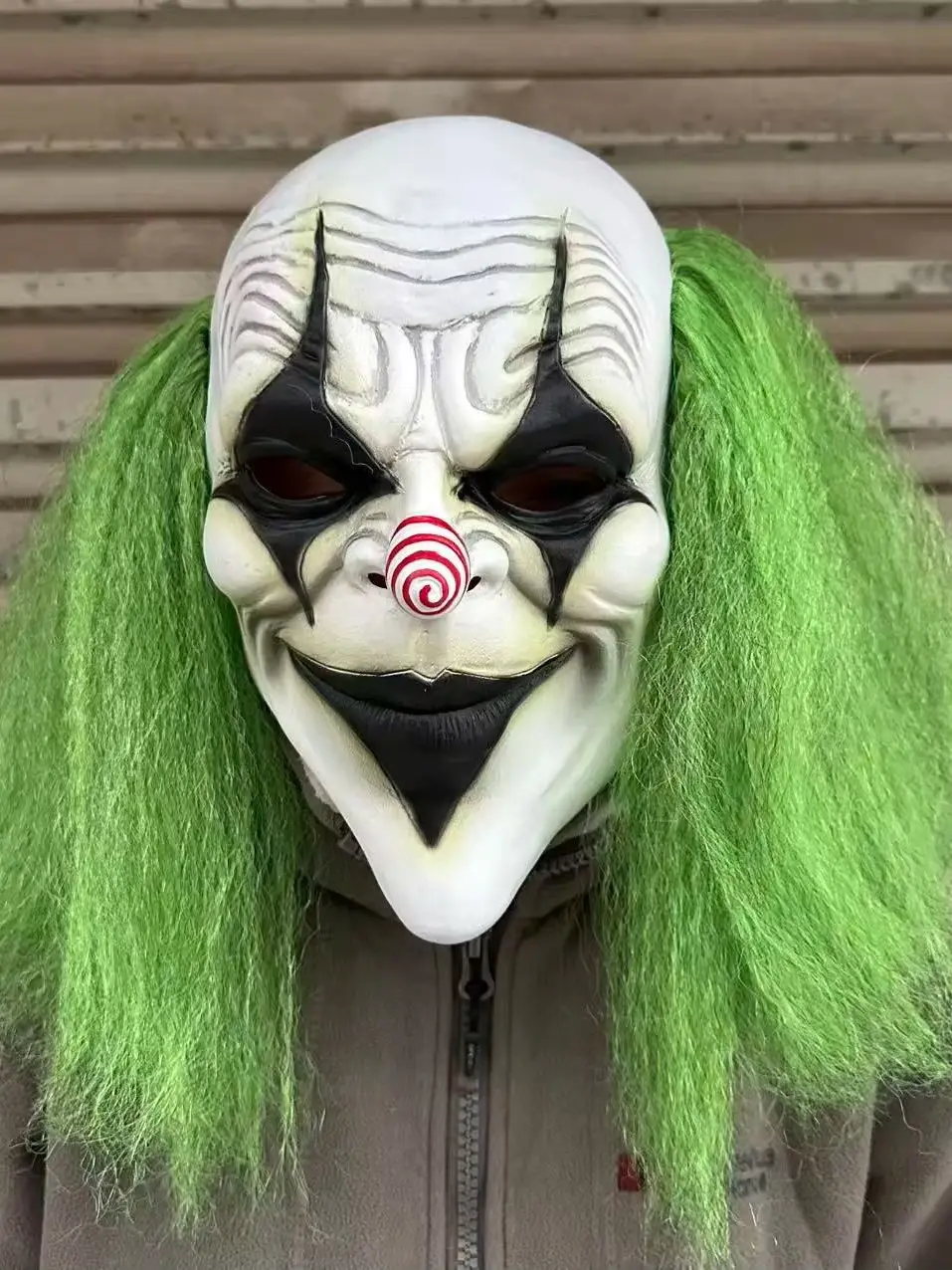 Furchteinflößender grünhaariger Clown mit Latexmaske und einer spiralförmigen rot-weißen Nase. Geeignet für Halloween-Kostümparty-Requisiten – Detail 1