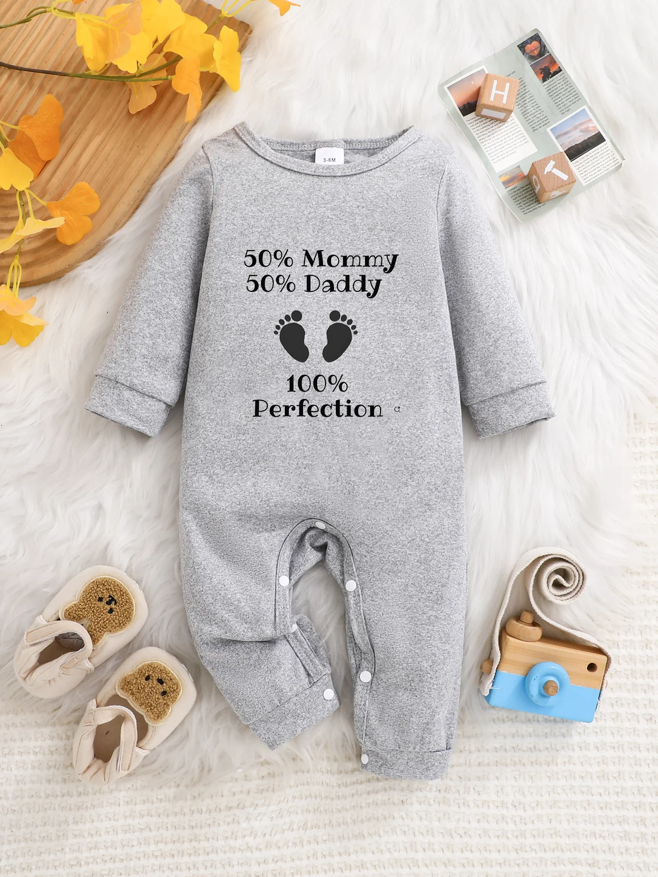 A baby long-sleeved onesie with interesting letter prints. It features a buttoned design for easy putting on and taking off, and