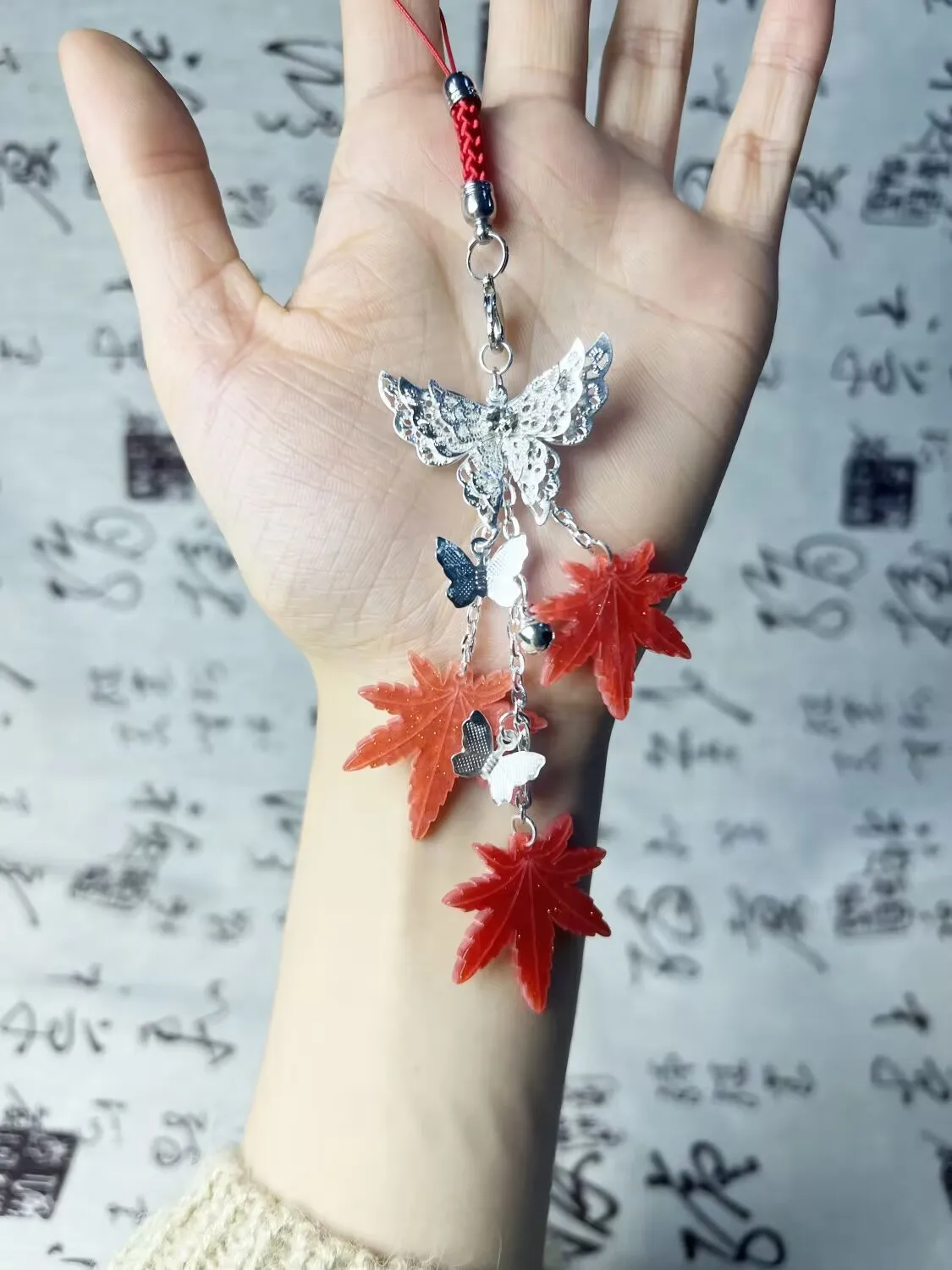 เทพธิดาสวรรค์ทรงพระราชากรุณาบุญคุณให้กับชาวเมืองดอกไม้ เซียเหลียน ด้วยเครื่องประดับรูปใบเมเปิ้ล กระดิ่ง และผีเสื้อสำหรับติดโทรศัพท์มือถือ