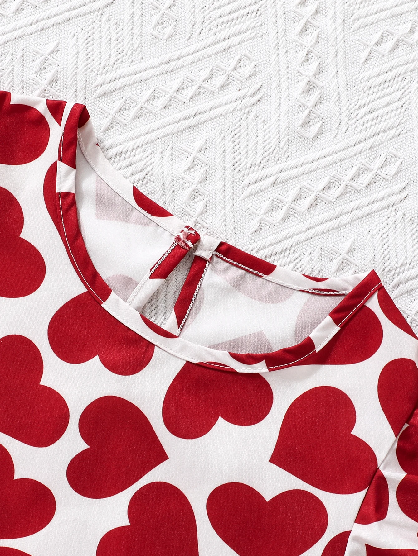 Abito da ragazza alla moda con stampa a cuore: abbinamento di colori rosso e bianco e design sul petto sul davanti