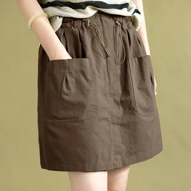 Moda elástica shirring emendado bolsos saias casuais roupas femininas 2025 verão novo solto all-match saias de cintura alta