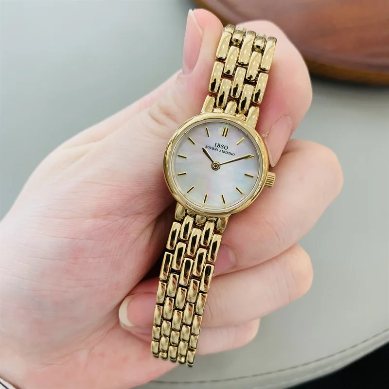 Elegant women's wristwatch, gold-plated, mother-of-pearl dial, minimalist ultra-thin design, understated luxury.