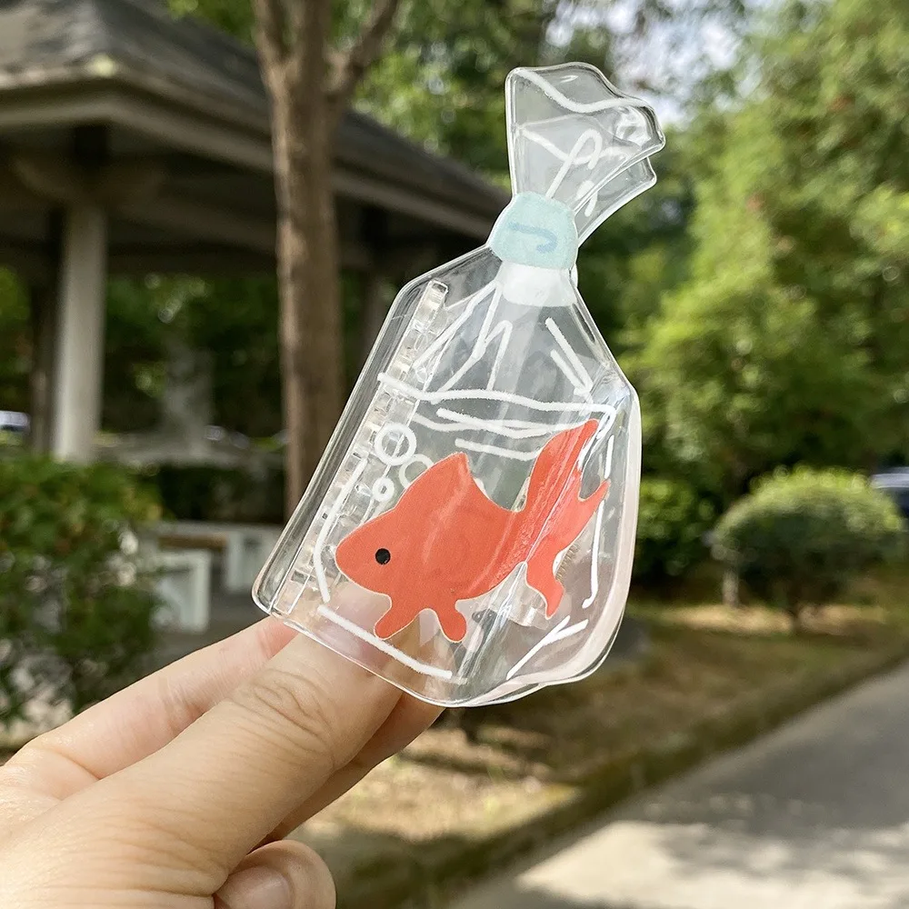 تصميم لخزان الأسماك الشفافة على شكل سمكة ذهبية، تصميم ممتع لخزان الأسماك باللون البرتقالي والأزرق، مناسب لتصفيف الشعر غير الرسمي