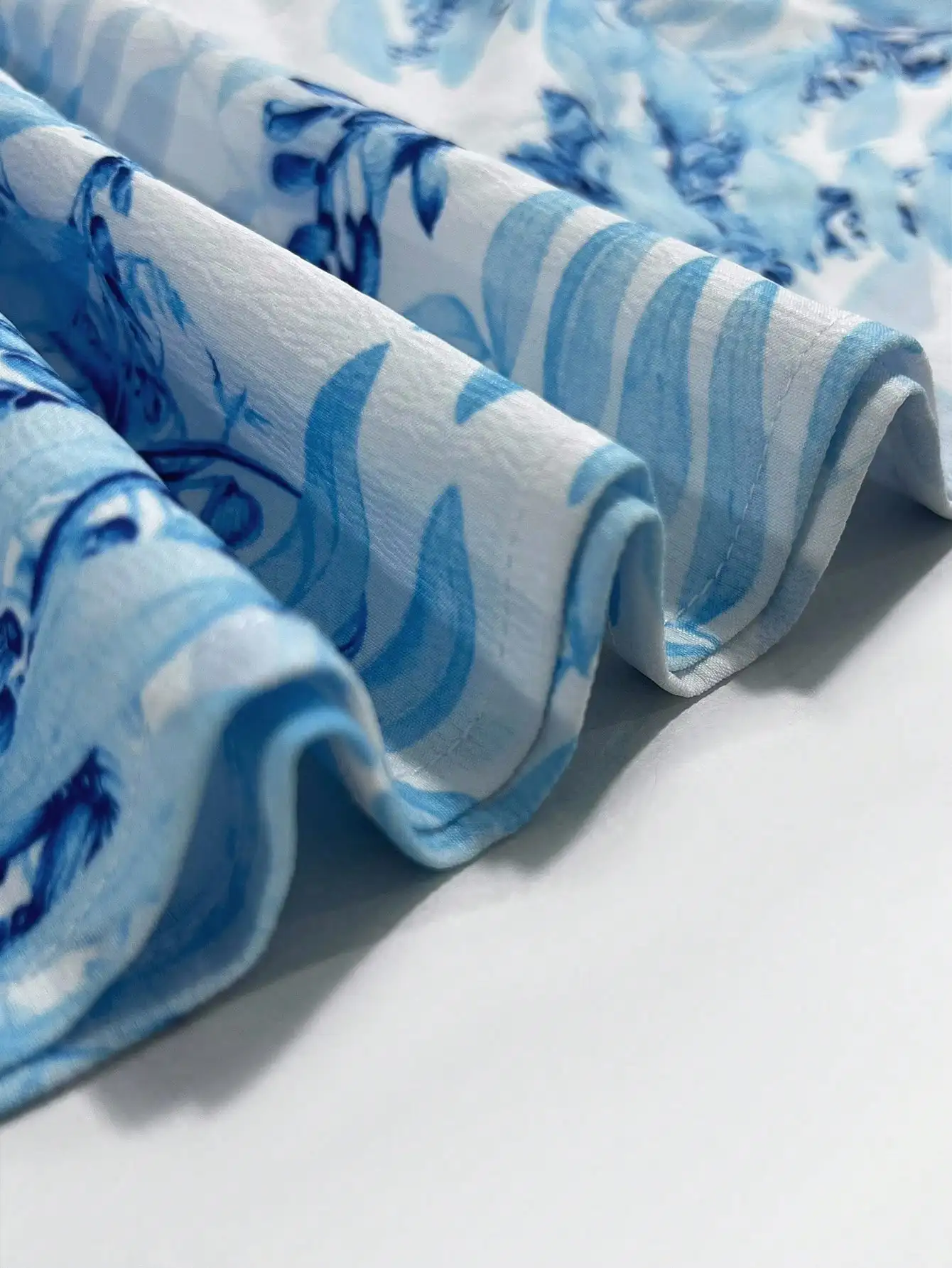 Damska niebieska sukienka maxi w kwiaty z dekoltem w serek, wycięciami i falbankami na rękawach, idealna na wakacje na plaży.