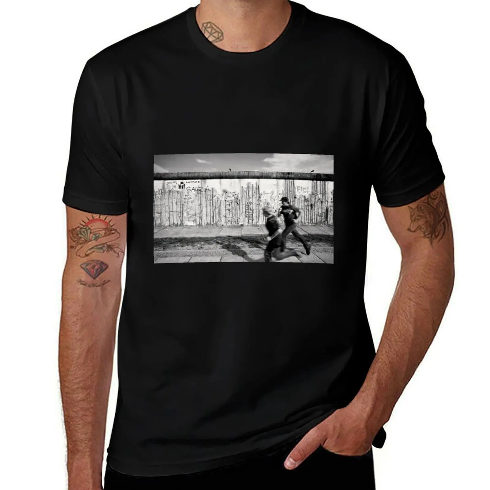

Two kids running along the remains of the Berlin Wall, Berlin, Germany T-Shirt designer shirts graphic shirts Men's t-shirt