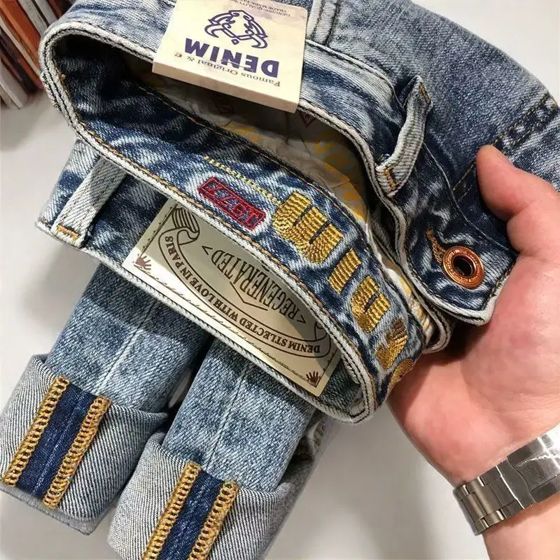 Jeans con tasca inclinata ricamata da uomo di marca alla moda ricamo slim-fit elastico piccolo dritto blu moda pantaloni casual da uomo
