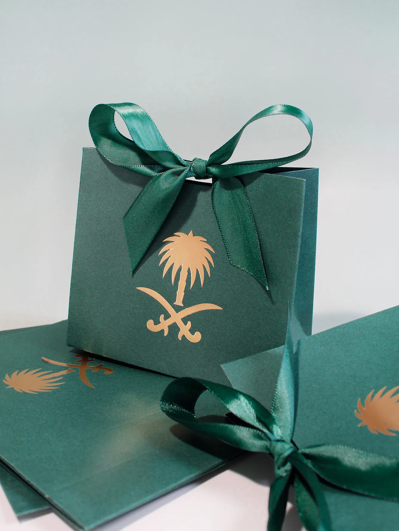 Elegant Dark Green Gift Boxes with Gold Palm Emblem and Satin Ribbons, Perfect for Sophisticated Gifts and Special Occasions