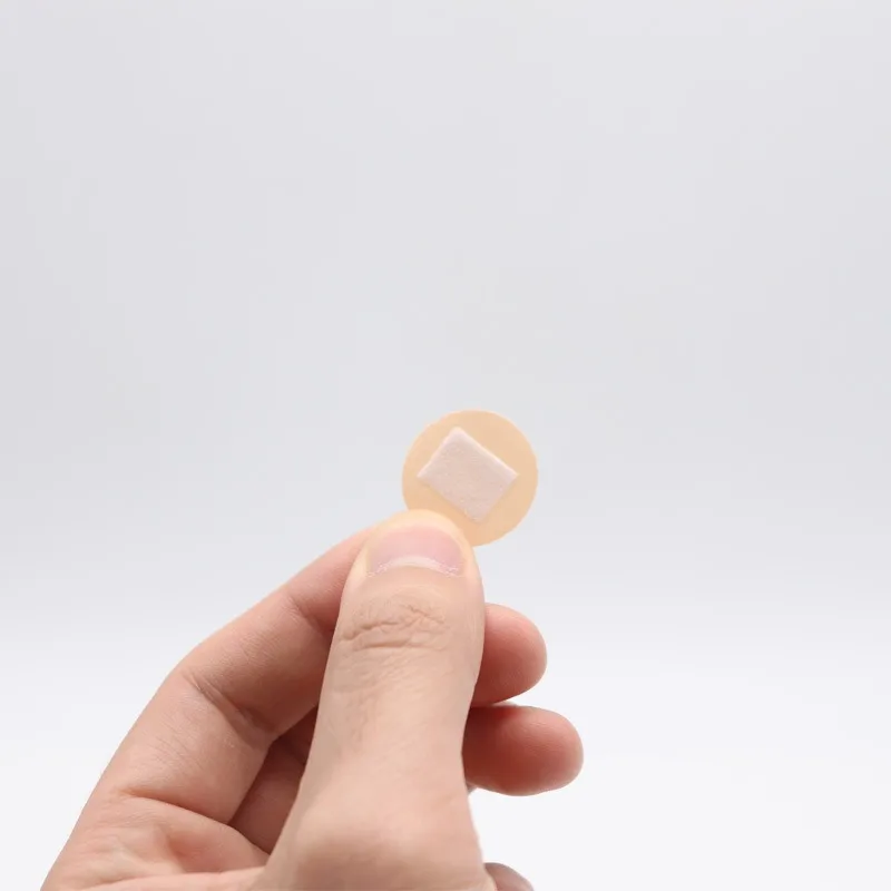 100 stuks mini ronde verbanden zelfklevend verband huidskleur met antiaanbakkussen PE ademende patch