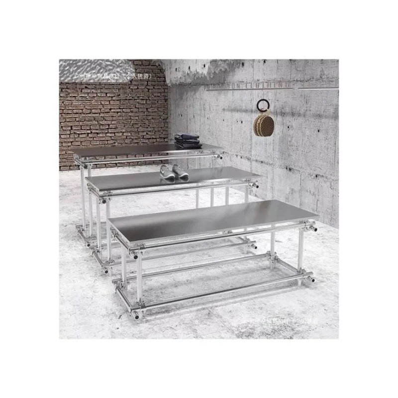 #In the middle of the island table in the clothing store, stainless steel men's clothing store shoes and bags are placed