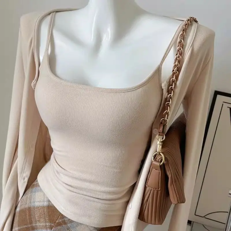 

Повседневный комплект из двух предметов: женский утягивающий кардиган на бретельках и дышащие хлопковые брюки для ранней осени. Модный тренд весенней коллекции.