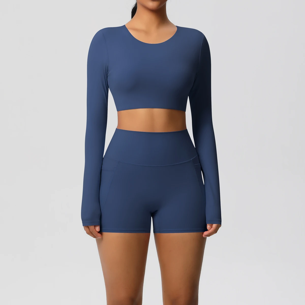 ชุดโยคะผู้หญิง ชุดออกกำลังกาย สีพื้น ทรงเข้ารูป แขนยาว แห้งเร็ว กางเกงขาสั้นฟิตเนสทรงพีชบัตต์เทิ้ล มีกระเป๋า