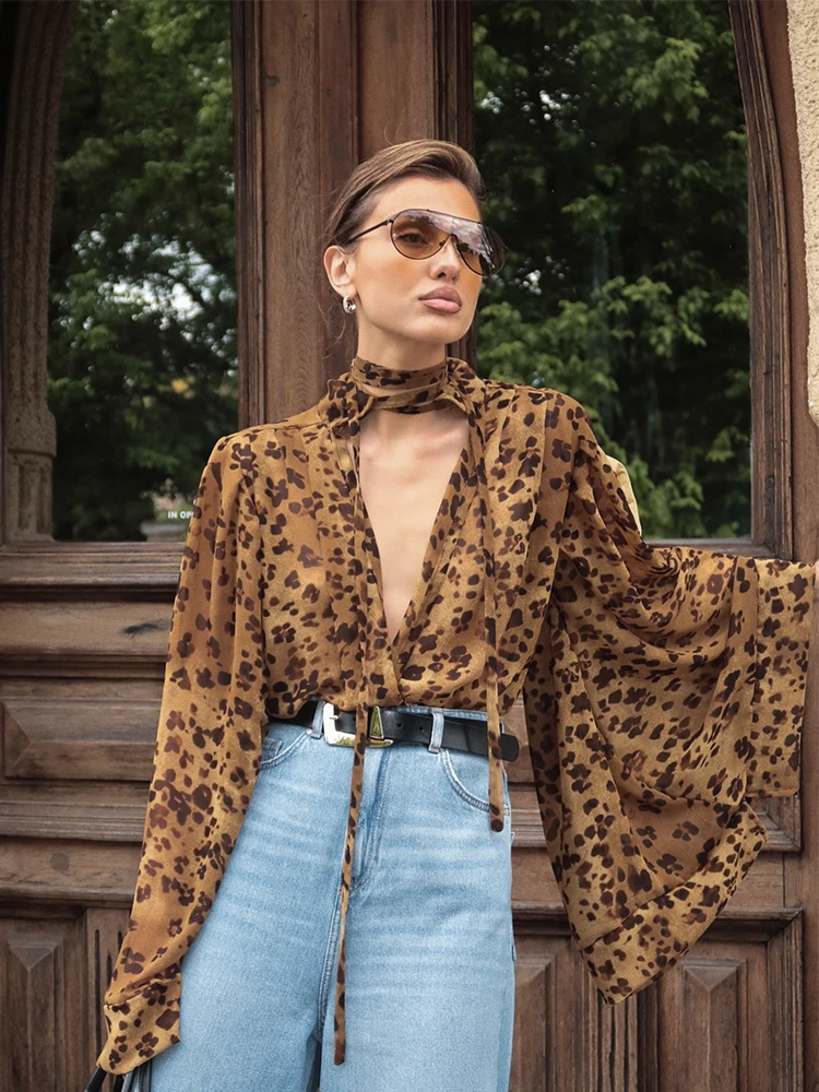 

Модные универсальные уличные топы весна 2026: женская блузка с леопардовым принтом, шнуровкой, глубоким V-образным вырезом, длинными рукавами и свободным кроем