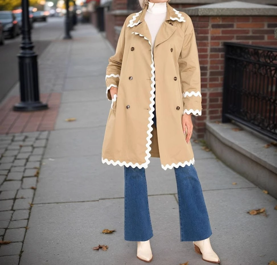 Biała marynarka z plisowanym kołnierzykiem, dwurzędowym zapięciem i podkreśloną talią oraz dwurzędowym zapięciem z przodu.