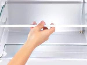 eine Hand, die eine Kühlschranktür öffnet.