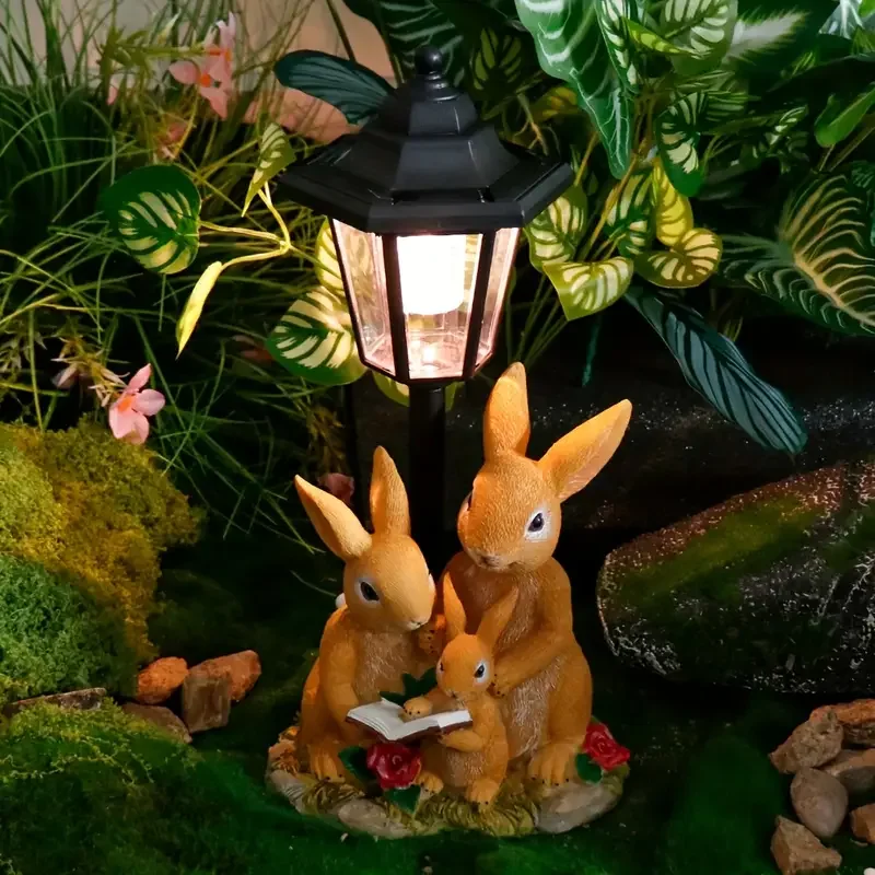 

Solar-Powered Rabbit Family Garden Light with Vintage Lamp, 3 Rabbits Reading Book Sculpture with Green Grass and Red Roses