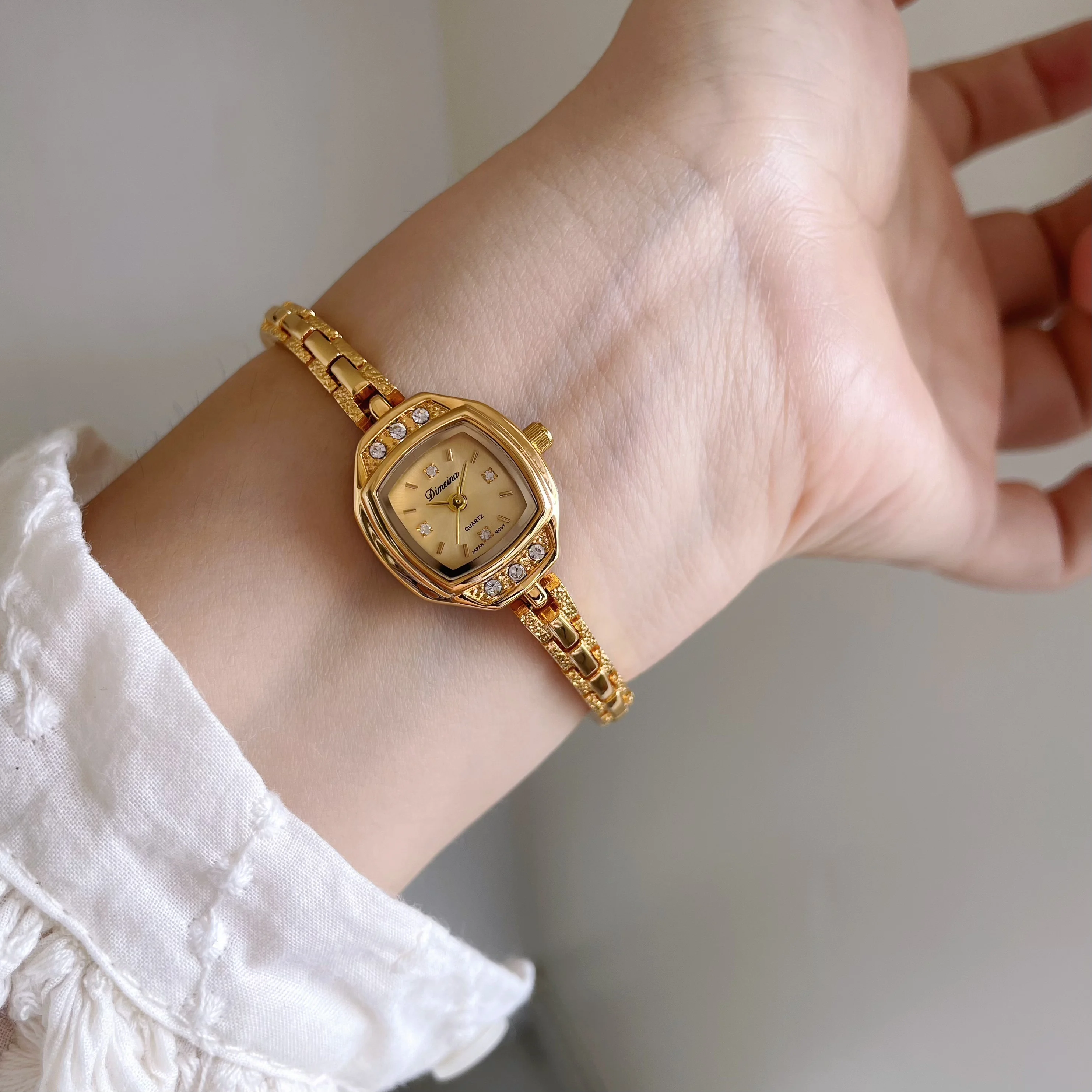 A sophisticated and elegant women's watch with a delicate gold strap,mini square dial, and a delicate, high-end design.